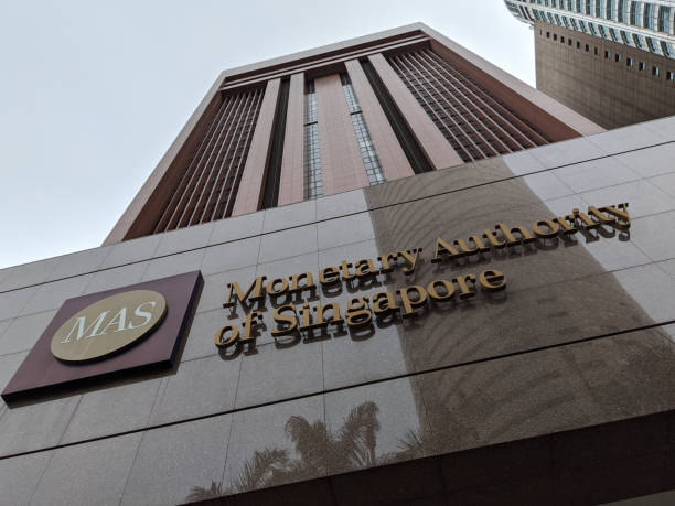 Monetary Authority of Singapore (MAS) sign with logo and its tall building on the background from angle looking up with a sense of greatness Singapore. May 2020. This picture was taken during the COVID-19 and depicts the MAS logo and sign with lettering at the entrance to the MAS (Monetary Authority of Singapore) building. The brown and tall building stands as the background depicting the greatness of the financial system. The Monetary Authority of Singapore is Singapore's central bank and financial regulatory authority. central bank photos stock pictures, royalty-free photos & images