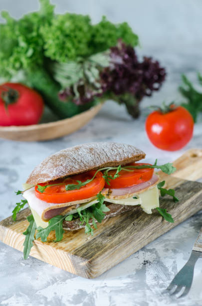 istock Delicious ciabatta sandwich with ham, tomatoes and arugula. 1223053379