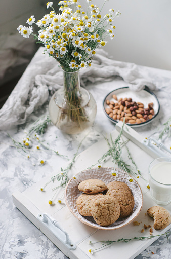 Homemade oat cookies on the table with flowers, healthy snack.