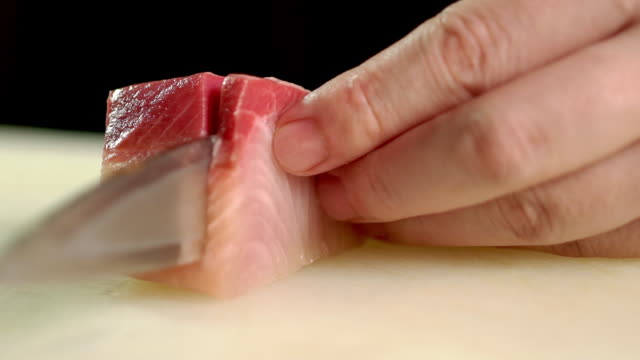Chef slicing some Hamachi sashimi in kitchen bar at the Japanese restaurant