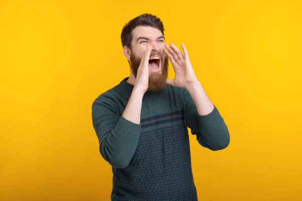 istock Bearded man is shouting or screaming loud with hands near his mounth. 1223053925