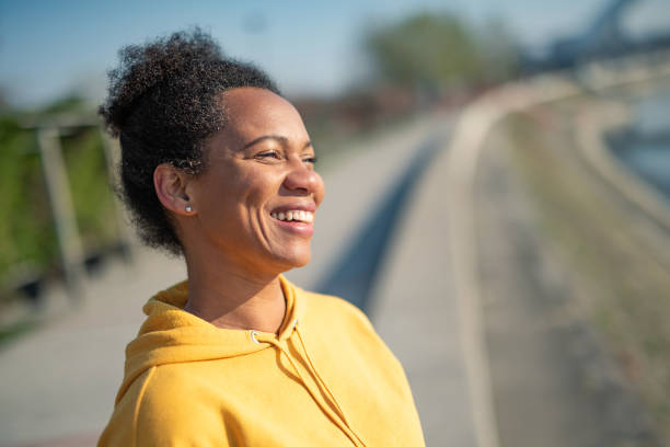 cheerful woman enjoying the sunrise in her town. - nostalgia joy laughing wellbeing imagens e fotografias de stock