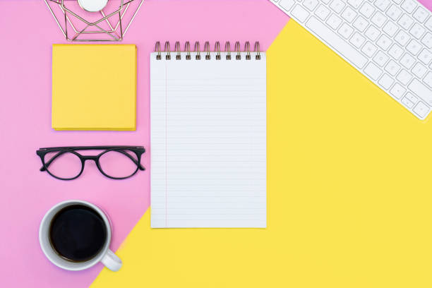 istock pink and yellow working place layout. note pad. writing. coffee, keyboard, glasses. spring concept. copy space flat lay 1223054906