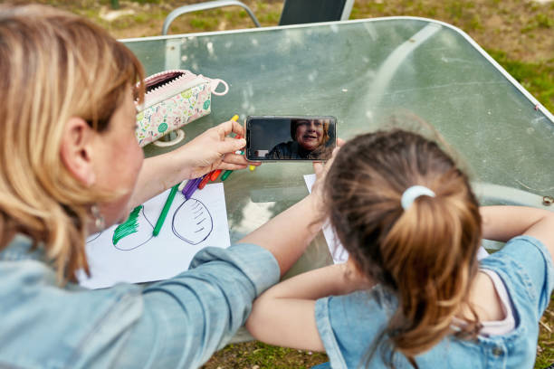 istock Mother and Young Daughter Outdoors Talking with Video Caller 1223054939