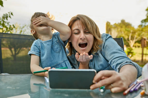 istock Expressive Mother and Daughter Interacting with Video Caller 1223054965