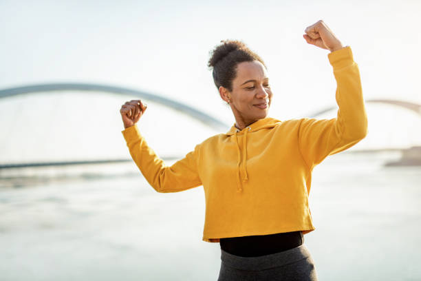 istock Happy strong woman flexing muscles. 1223055119