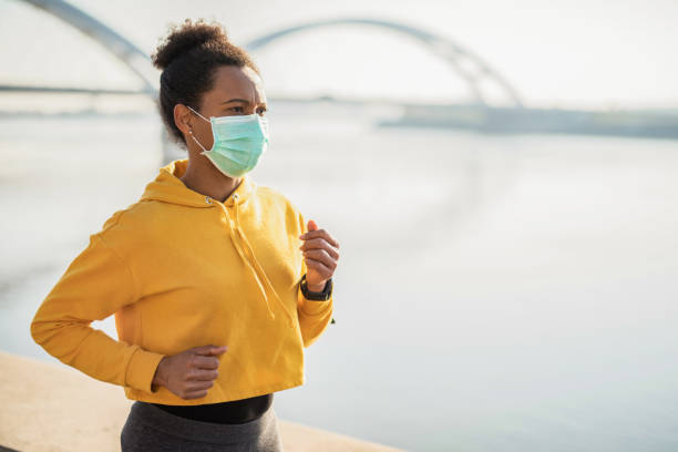 Woman running with protective face mask.