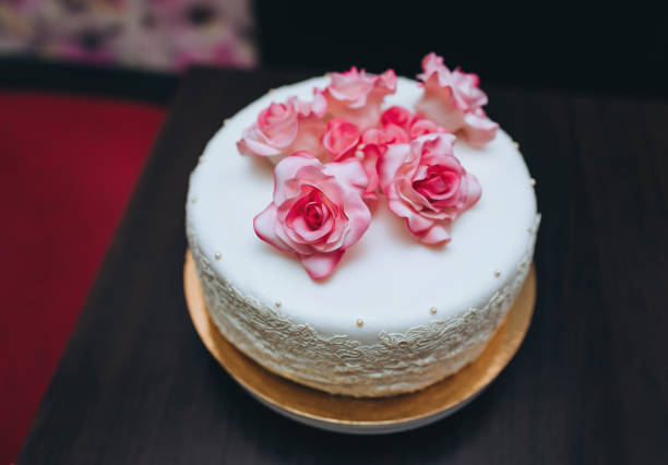 istock A single tier white wedding cake with pink rose flowers from a pastry glaze. 1223056511
