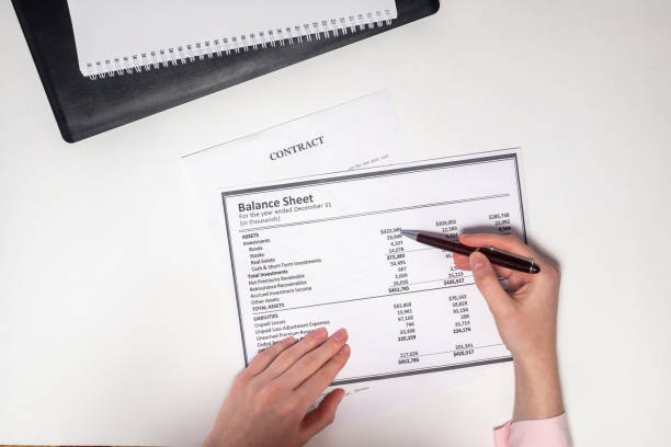 istock Balance sheet and other documents are checked by female hands with pen. Accounting concept 1223057107
