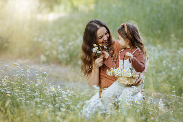 mère heureuse et petite fille ramassant des fleurs - mother child beautiful nature photos et images de collection