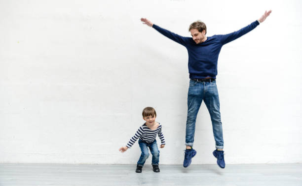 istock father and son jumping together 1223057216