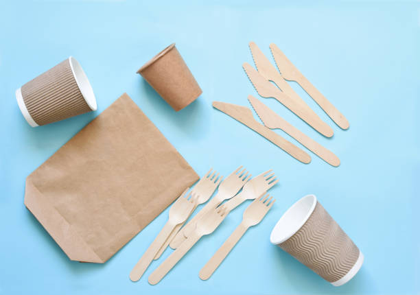 istock Disposable eco-paper dishes: glass, cardboard, bag, fork, knife. On an empty blue background. The layout of wooden cutlery on a blue background. 1223060961