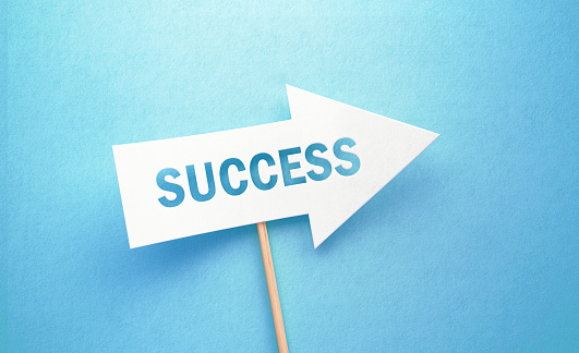 Success written white arrow on blue background. Horizontal composition with copy space. Success concept.