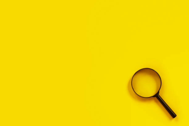 istock Black metal magnifier on a yellow paper background. 1223061117