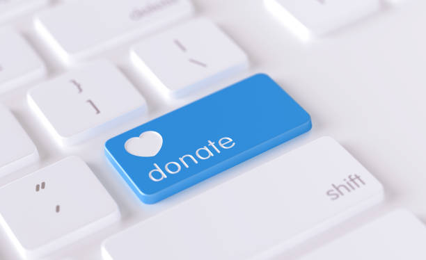 Modern Keyboard Button with Donation Icon - Charity Concept Donation  icon written on a blue button of a computer keyboard. Horizontal composition with selective focus and copy space. High angle view. Charity concept. charitable donation stock pictures, royalty-free photos & images