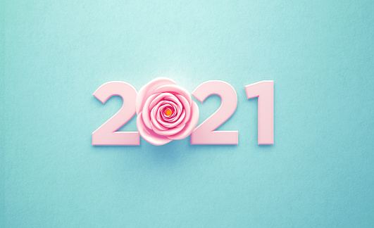 Pink rose and number forming 2021 over turquoise background. Horizontal composition with copy space. New year concept.