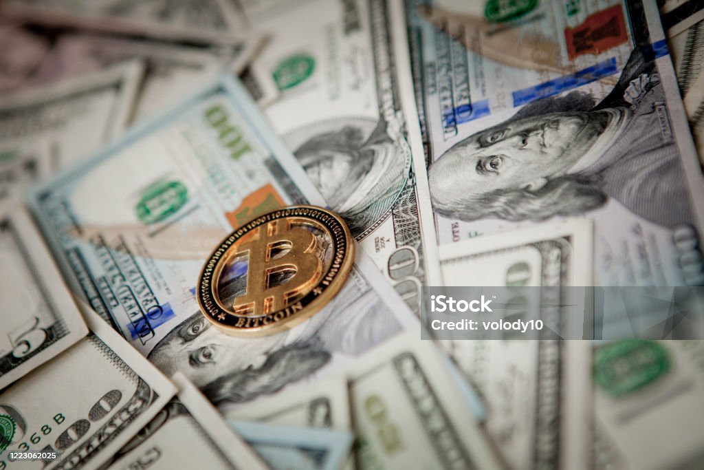 Golden Bitcoin on US dollar bills. Electronic money exchange concept Golden Bitcoin on US dollar bills. Electronic money exchange concept. Bitcoin Stock Photo