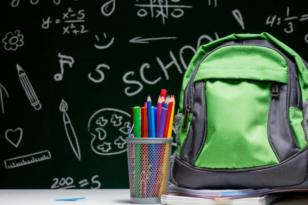 education concept - green backpack, notebooks and school supplies on the background of the blackboard - chancellery imagens e fotografias de stock