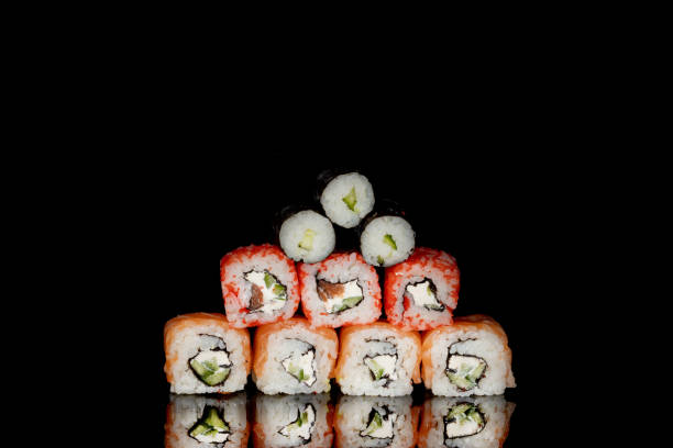 istock Philadelphia roll with salmon, cheese and cucumber on a black background with reflection. Sushi Philadelphia 1223062229