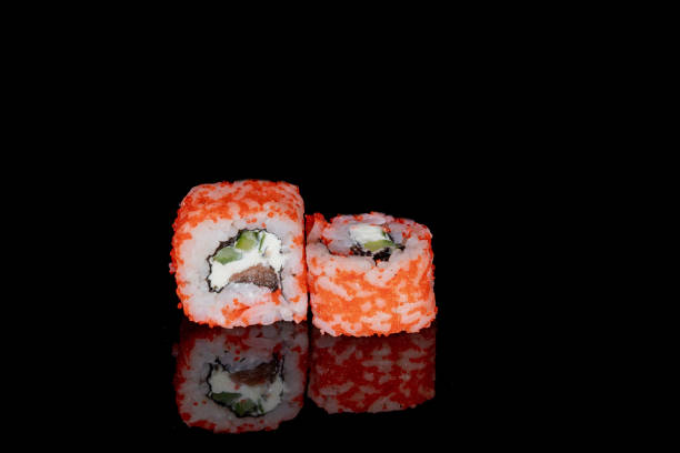 istock Philadelphia roll with salmon, cheese and cucumber on a black background with reflection. Sushi Philadelphia 1223062279