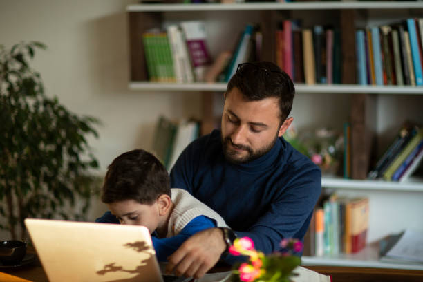 istock Fahter is showing his boy things on a laptop 1223062361