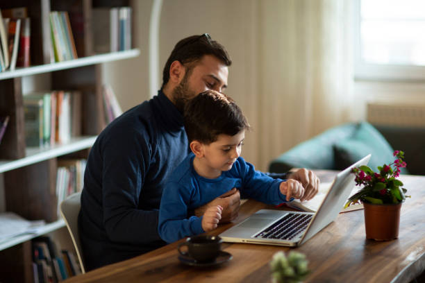 istock Fahter is showing his boy things on a laptop 1223062613
