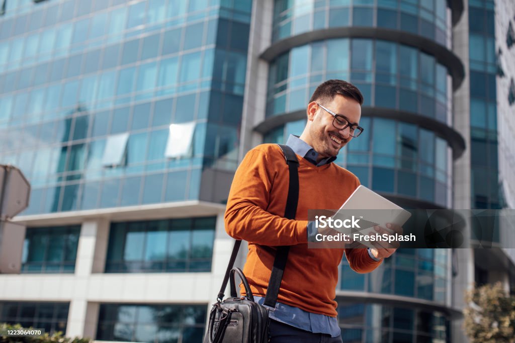 Succesvolle moderne Jonge Zakenman die een Digitale Tablet op de Straat gebruikt - Royalty-free Oranje Stockfoto