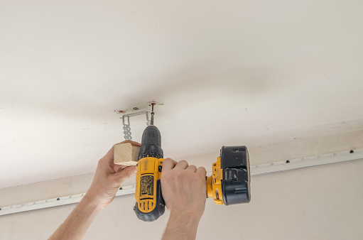 Construction worker installs plasterboard ceilings and insulation. drywall ceiling