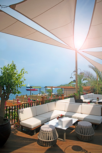 Cozy veranda next to the beach with wicker furniture and an umbrella. Nessebar, Bulgaria