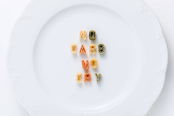 istock words NO CARB NO CRY from dry multi-colored pasta on a white plate. 1223067288
