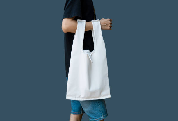 istock Man is holding bag canvas fabric for mockup blank template on gray background. 1223067598