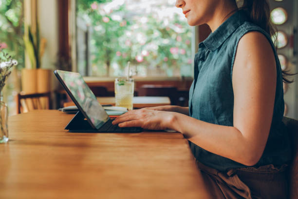 istock Working Remotely: Unrecognizable Woman Using her Tablet to Work at a Local Cafe 1223068017
