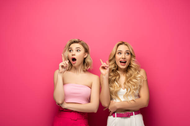 istock Excited blonde girls having idea on pink background 1223068416