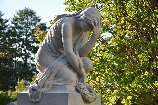 Statue of a woman at a cemetery gravesite
