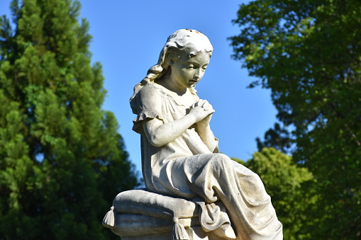 Statue of a woman at a cemetery gravesite