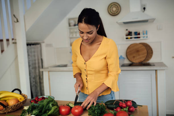 istock Happy young vegan woman preparing a meal 1223072200