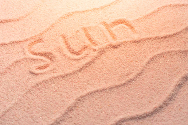 RESORT lettering on sand with wave and evening light. Minimal exotic vacation and travel concept, Flat lay top view copy space