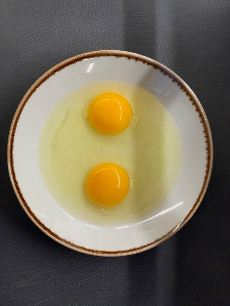 istock Two raw chicken eggs cracked into a porcelain plate 1223075393