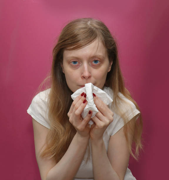 istock Young girl blowing nose into tissue 1223075981