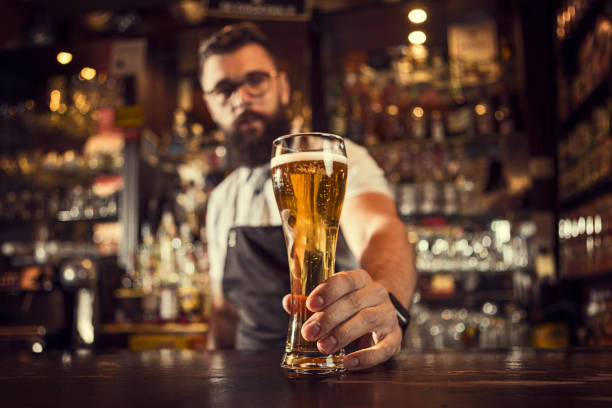 bartender serviert bier - bartresen fotos stock-fotos und bilder