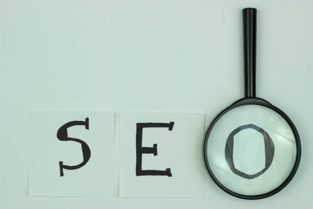 istock SEO, concept of search engine optimization ranking, magnifying glass indicating abbreviation of SEO alphabets on white paper, idea of promoting traffic to a site. 1223076187