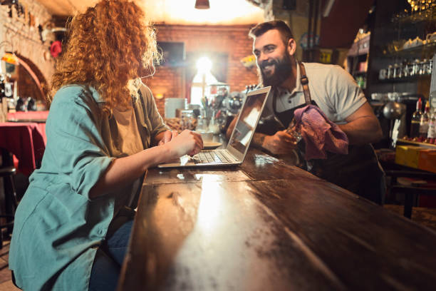 istock Smiling manager and bartender talking to each other in pub 1223076199