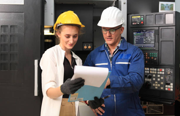 istock Male and Female Industrial Engineers in Hard Hats Discuss New Project while Using Laptop. They Work in a Heavy Industry Manufacturing Factory. 1223078172