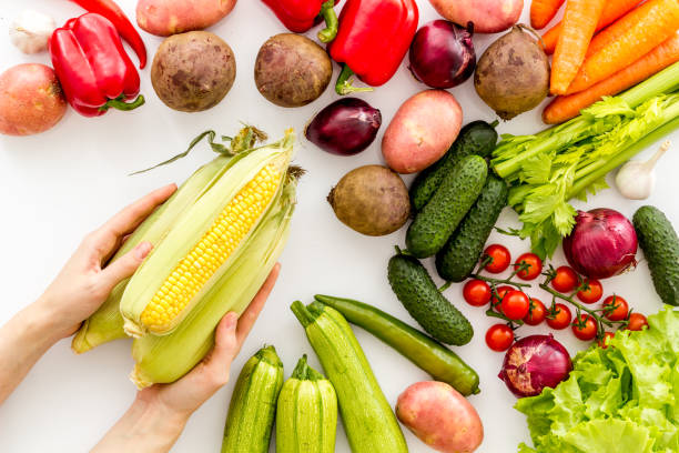 istock Pick vegetables. Corn in hands near autumn harvest on white background top-down 1223079672
