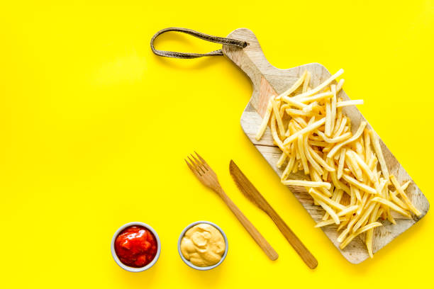 istock French fries served on cutting board on yellow table top-down copy space 1223080562