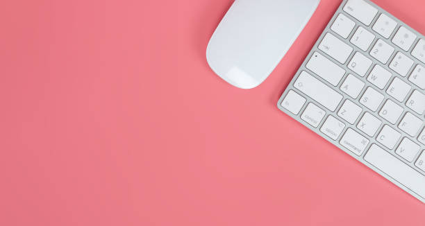 istock Flat lay, top view office table desk. Workspace with keyboard and mouse on pink background 1223085320