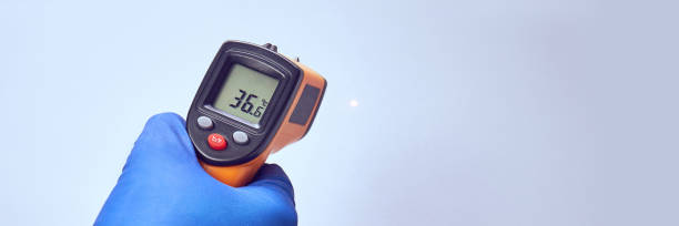 istock hand in blue glove holds ir thermometer high temperature 1223089299