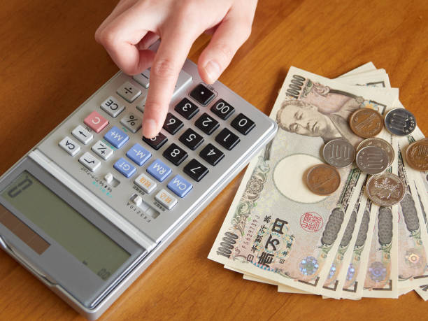 eine japanerin, die geld berechnet - japanischer yenschein stock-fotos und bilder