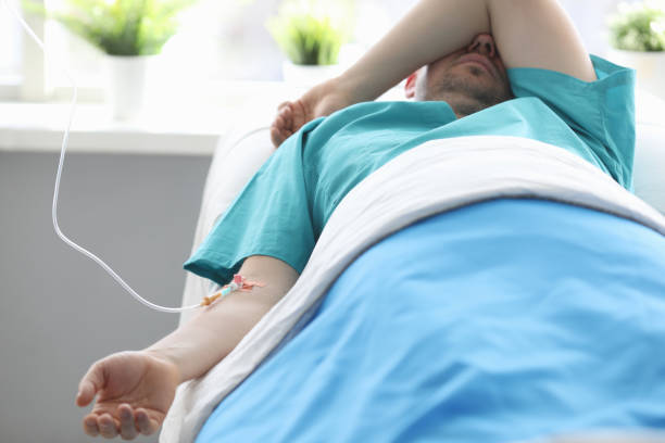 istock Unshaven man lying hospital bed under dropper 1223089351