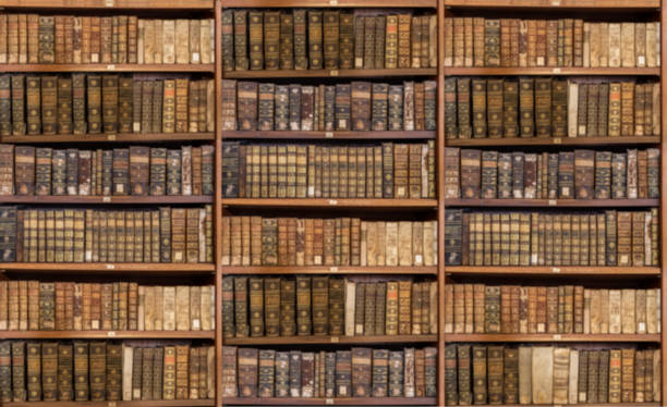 Defocused shelves of old antique books for background Defocused and blurred image of old antique library books on shelves for use in video conferencing background library photos stock pictures, royalty-free photos & images